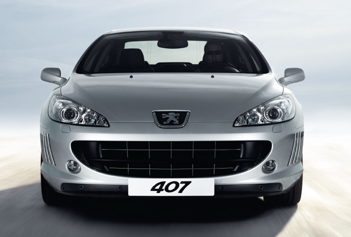DESIGN EXTERIEUR DE PEUGEOT 407 Coupé: Voici une photo de face de la Peugeot 407 Coupé. On reconnaît les ouies latérales sur le bouclier, la baguette du bas en plastique (bof!) où sont intégrés les capteurs 
du radar de parking. La grille d'aération est élargie par rapport à la Peugeot 407 berline, ce qui lui donne un aspect encore plus sportif et dynamique. Au milieu de cette gueule béante se trouve un renfort en plastique (encore...). 